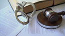 Dealer/Title Fraud Investigations - Handcuffs, book and gavel on papers