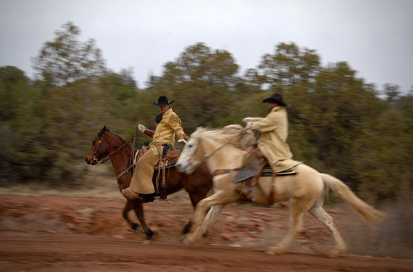 Two Hashknife Pony Express cowboy pass a mailbag