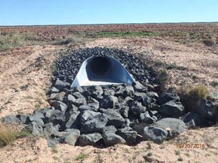 Large rocks surround drainage pipe