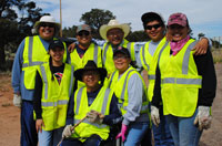 Group of Adopt a Highway volunteers wearing safety vests