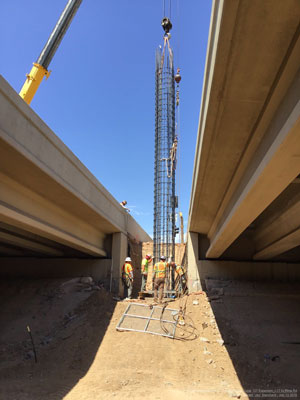 Crews lower the steel rebar cage into a 70-foot-deep shaft for the new abutment that will provide support for the freeway bridge being widened over the Cave Creek Wash near Seventh Street.