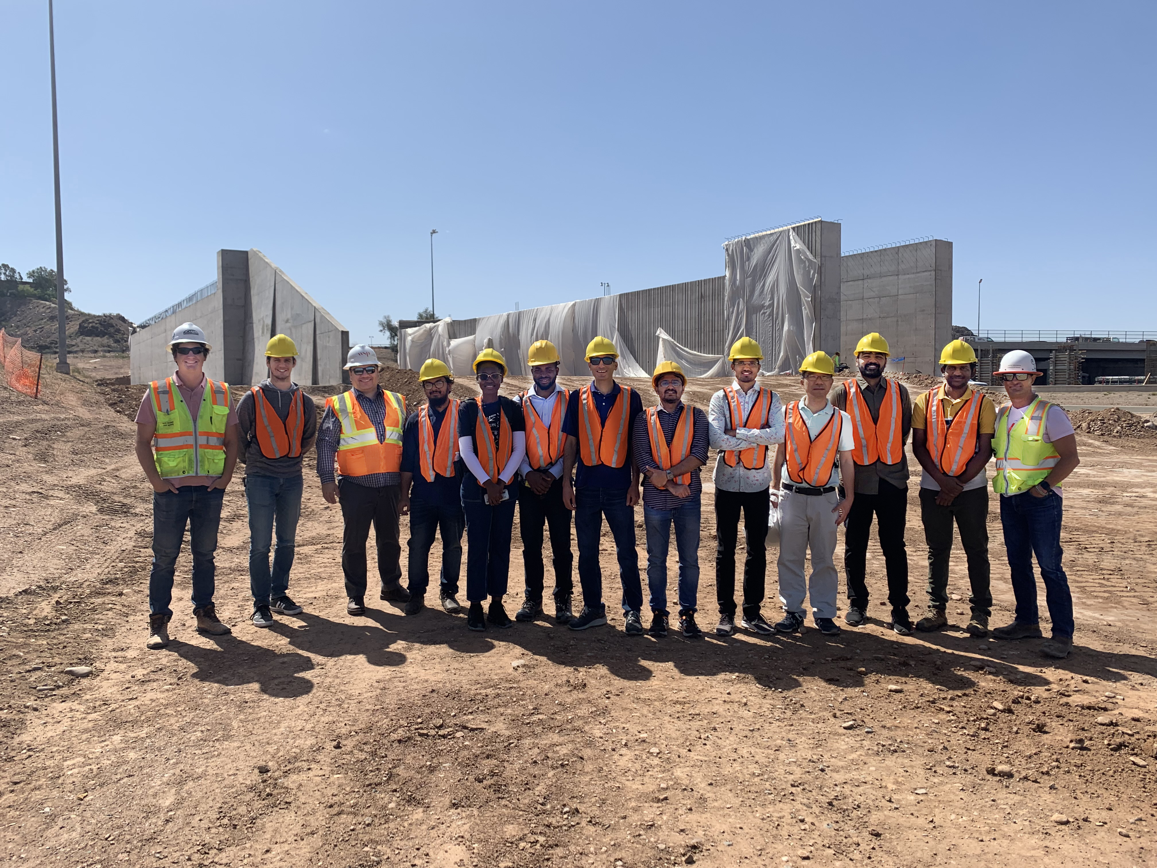 Thirteen people standing in construction safety gear