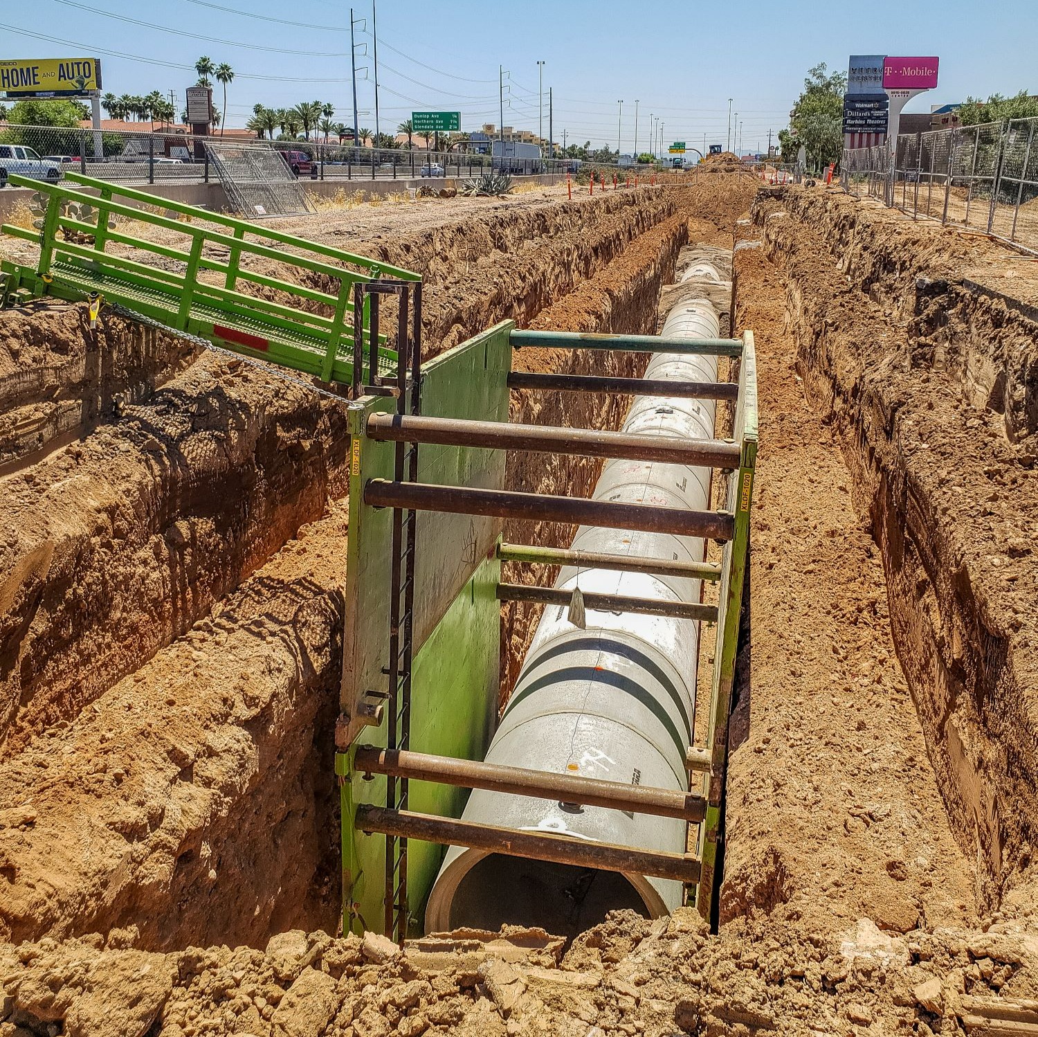 Construction of an underground drainage system. A concrete pipe is partially buried in the ground.