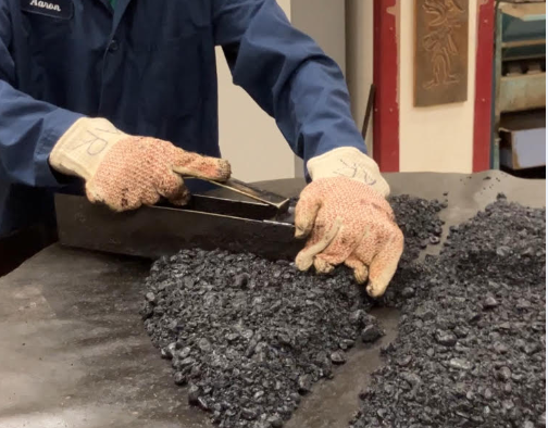 A lab worker takes samples of asphalt.