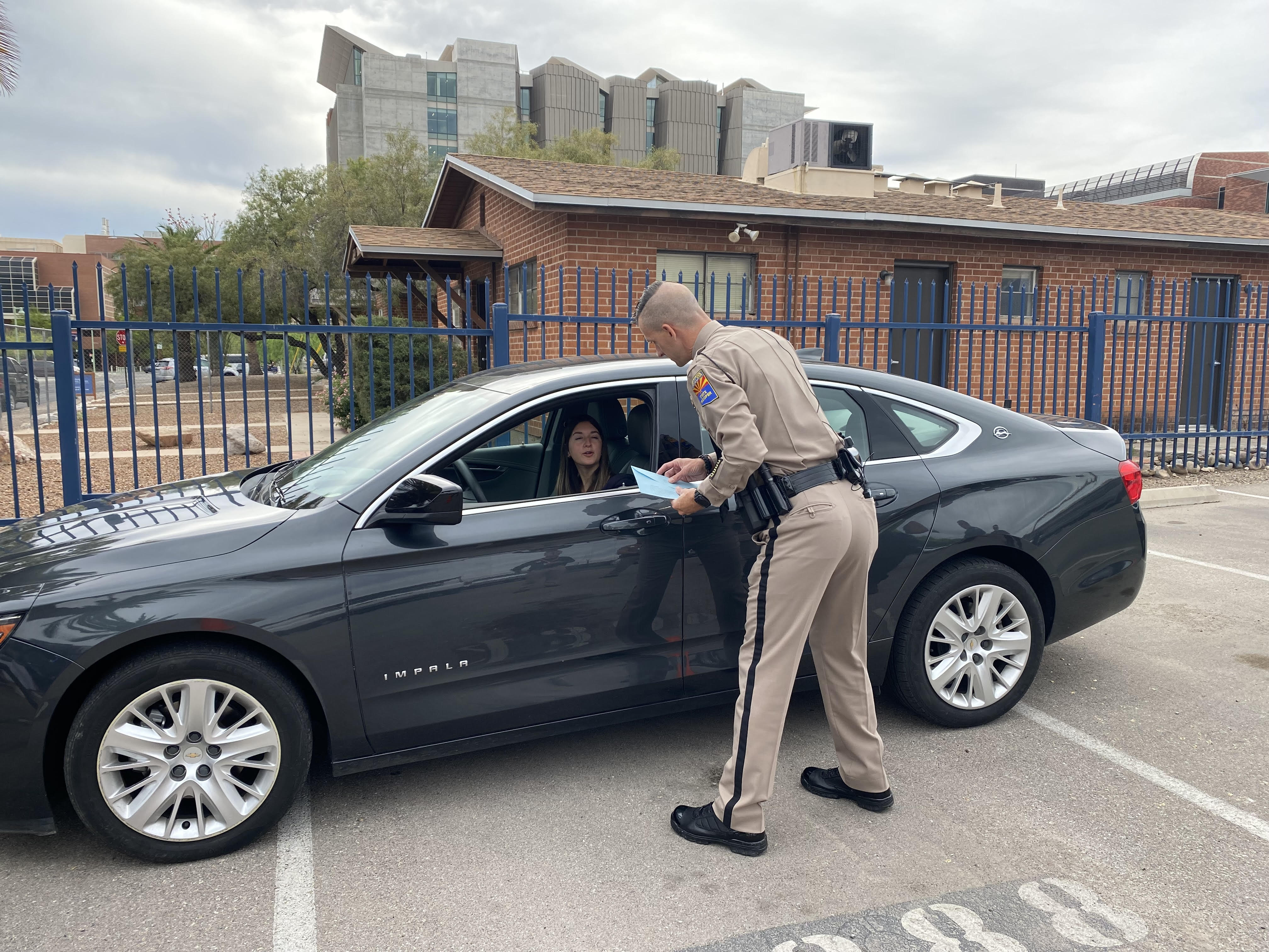 A motorist handing a blue envelope to a DPS trooper during a demonstration of the program.