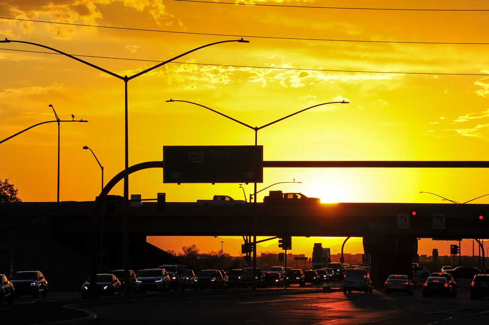 freeway cars at sunset with a bright orange sky