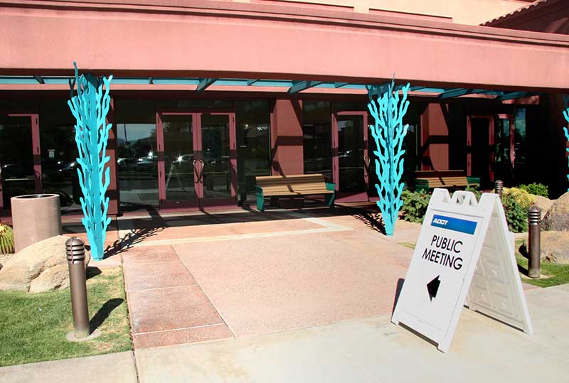 Public Meeting sign in front of building entrance