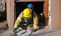 Firefighter crawling out of building during training