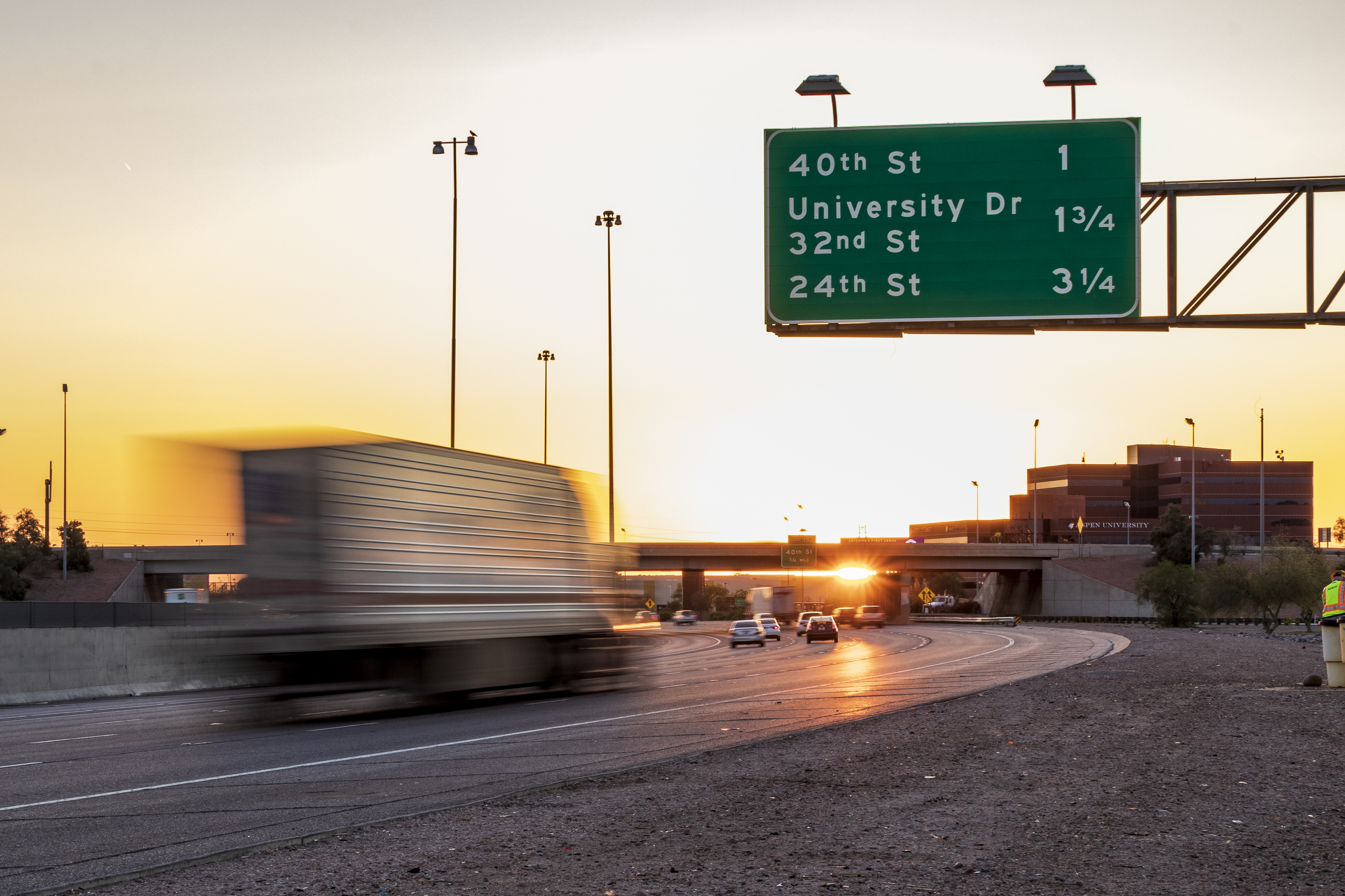 Semi-truck on highway at sunset