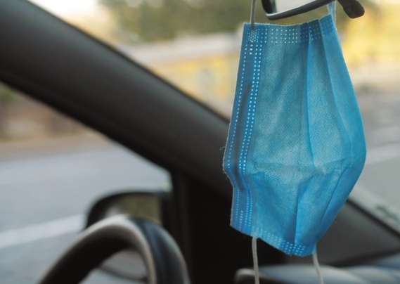 Mask hanging from rear view mirror