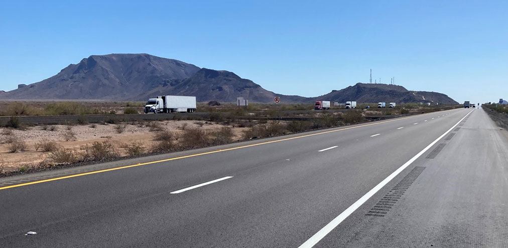 Freshly repaved lanes of Interstate 10 between Salome Road and Tonopah, showing smooth road asphalt, clear lane markings, and distant mountains.