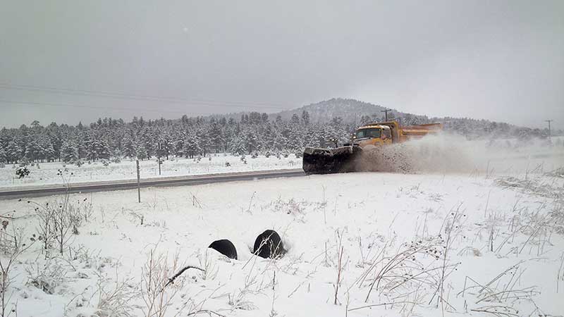 Tow plow clears snow from a highway