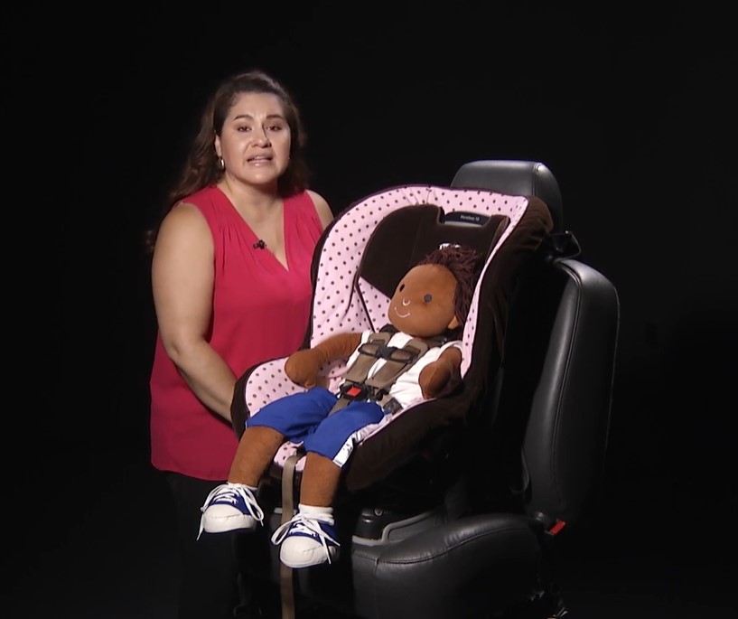 Speaker demonstrates proper child seat use
