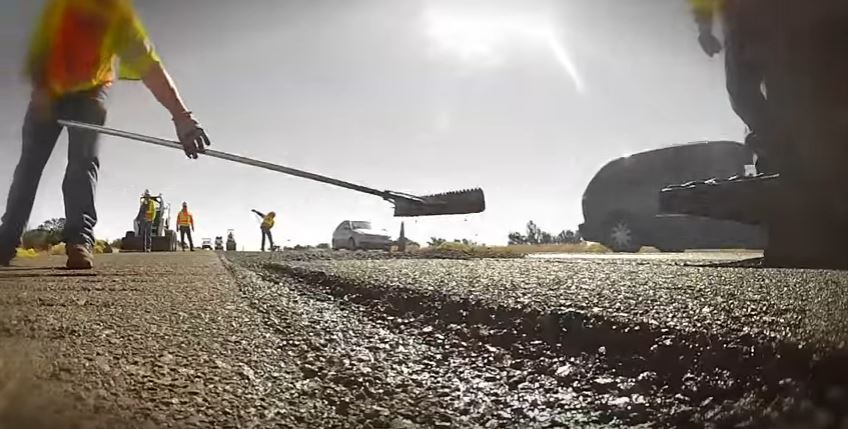 Workers laying asphalt