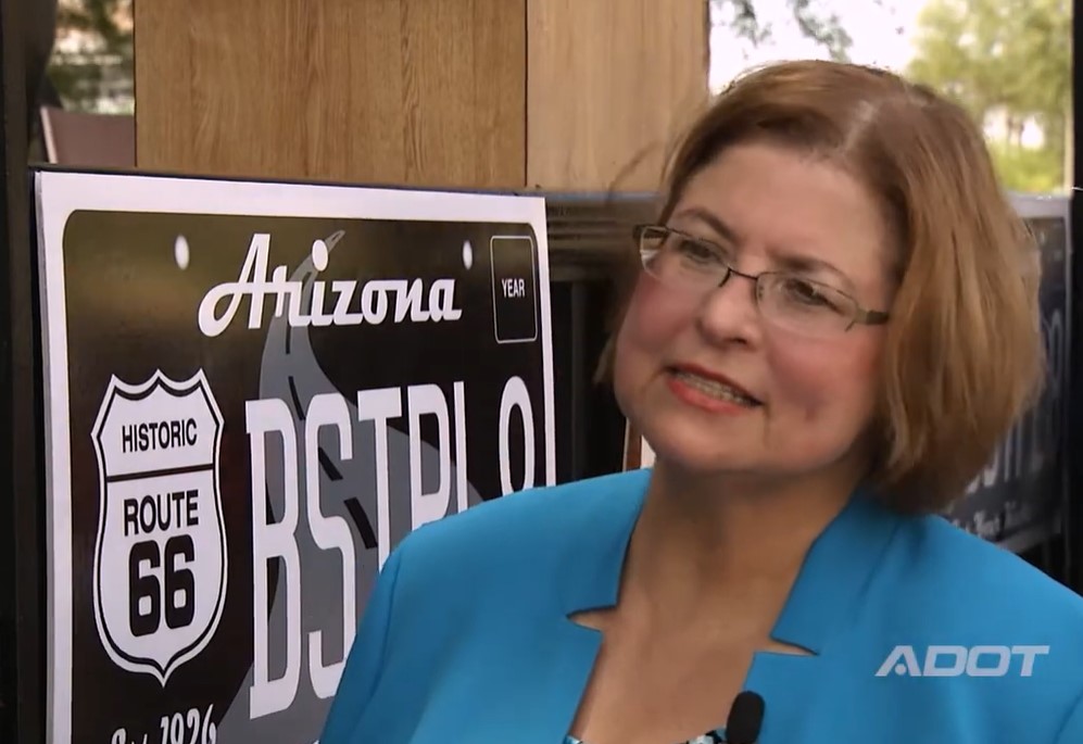 Cyndi McCabe next to representation of Route 66 license plate