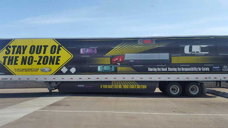 Semi-trailer message warns motorists to avoid trucks' blind spots.