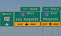 Highway signs showing directions for North 303, I-10 West to Los Angeles via Exit 104B, and I-10 East to Phoenix via Exit 104A.