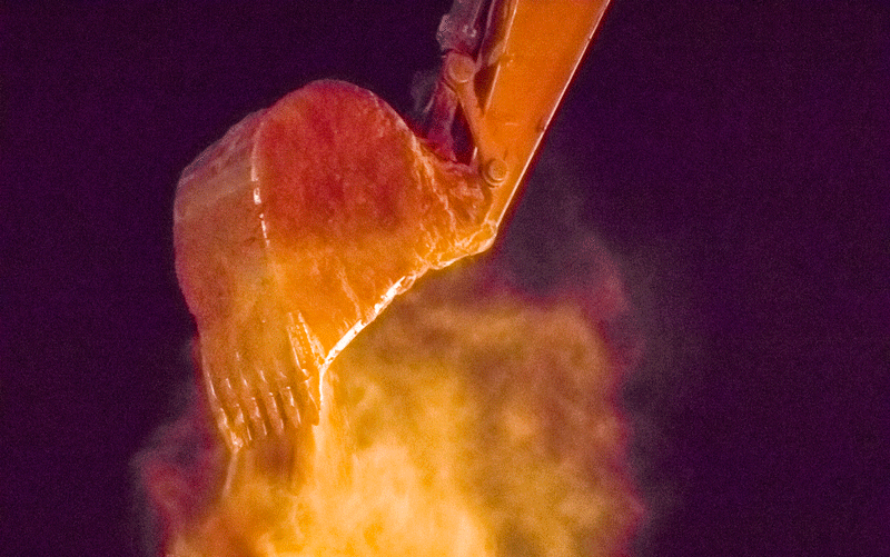 NIghttime dirt haul with dust reflecting orange light