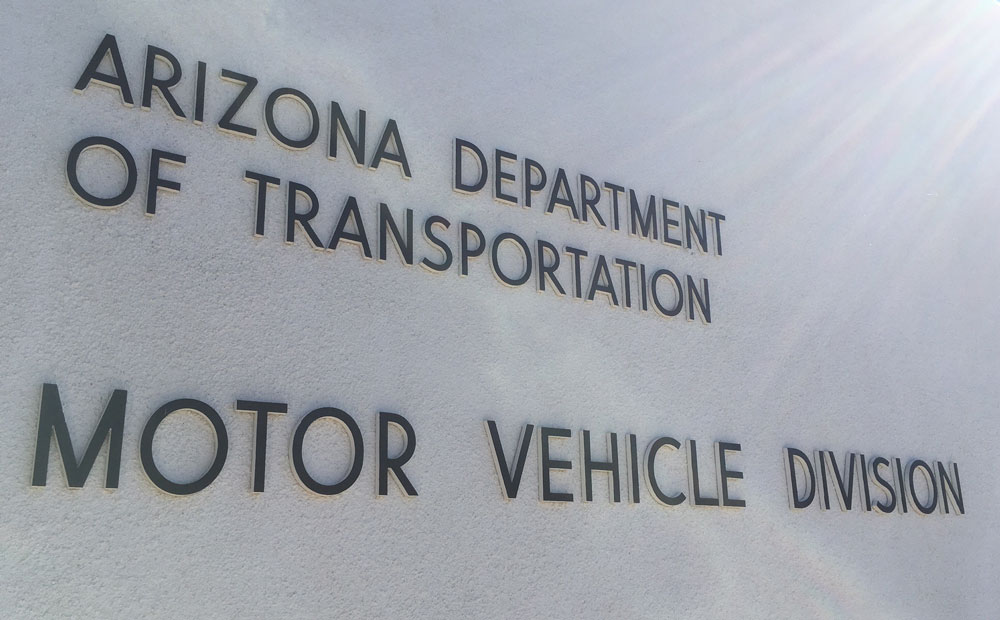 The words Arizona Department of Transportation Motor Vehicle Division are displayed on a light-colored wall.