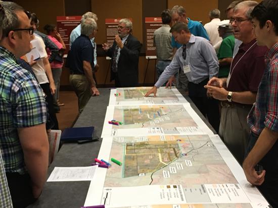 People at public meeting look at tabletop map