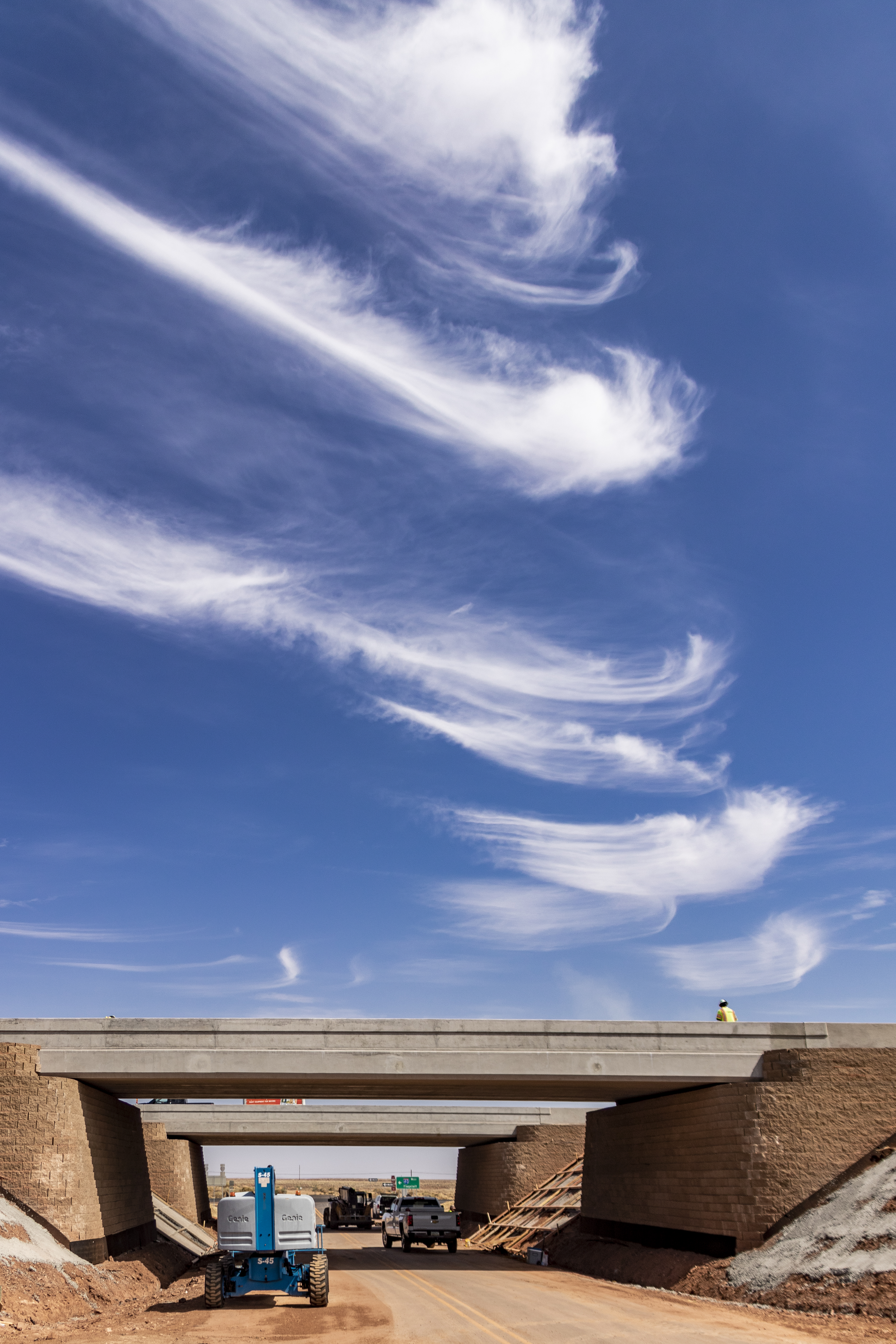 Cirrus clouds in sky about interchange bridge construction