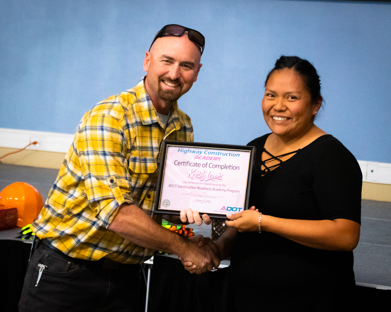 ADOT representative presents construction academy graduate with her certificate