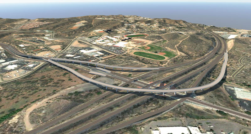 Aerial view of the Arizona Route 189 interchange with multiple overpasses surrounded by hilly terrain and buildings.