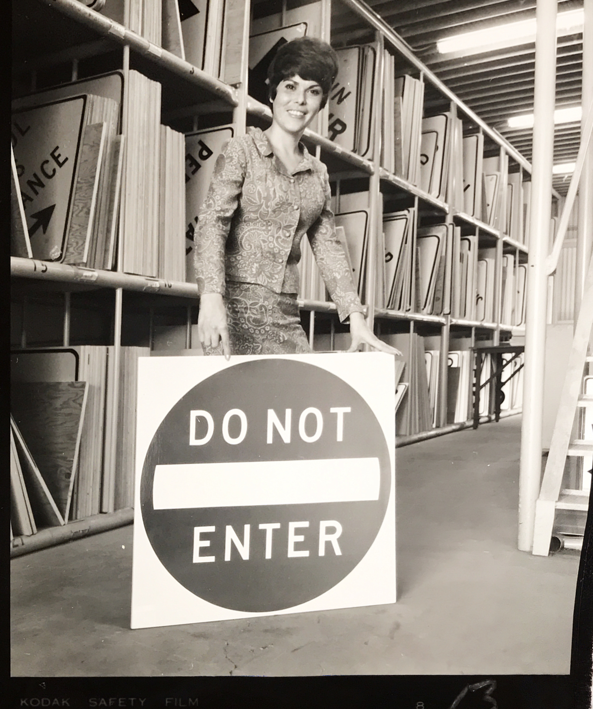 A woman holding a Do Not Enter sign