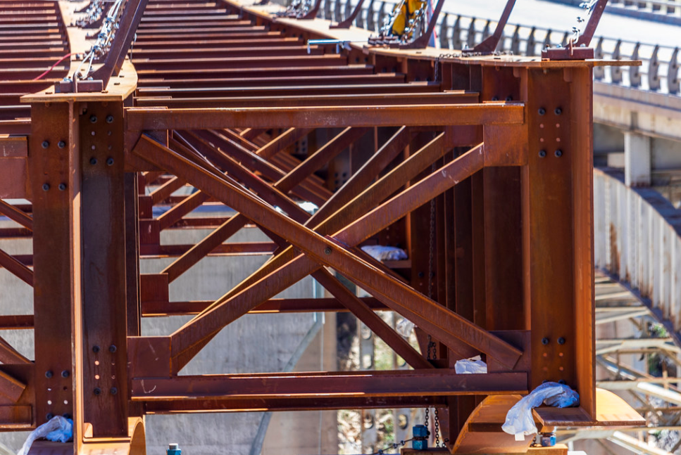 Close-up of a steel bridge under construction showing beams and support structures.