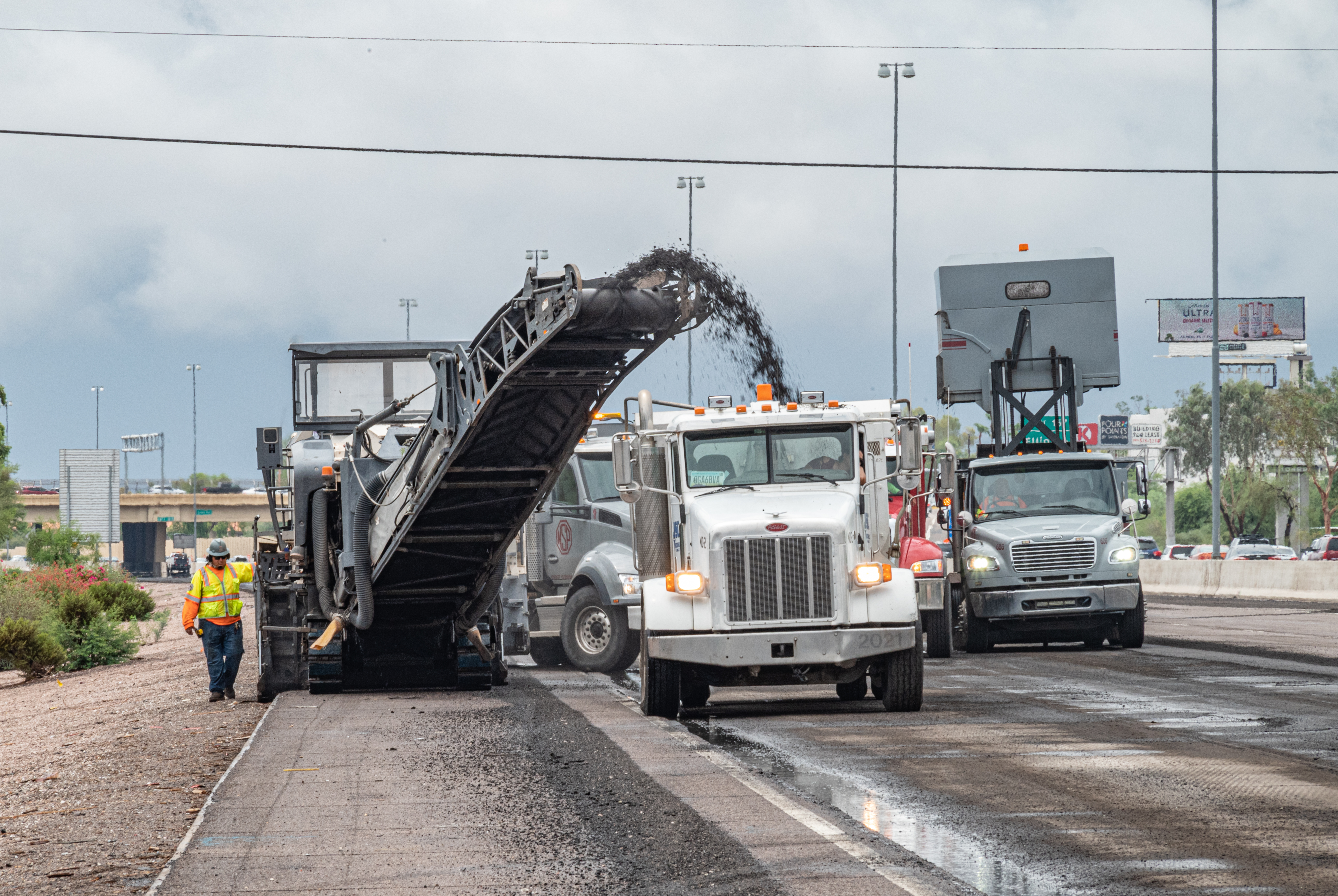 Equipment removing asphalt and conveying it into a truck trailer