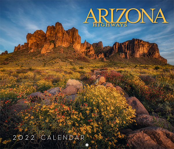 Desert landscape with wildflowers and rocky mountains at sunset, featured on the cover of the Arizona Highways 2022 Calendar.