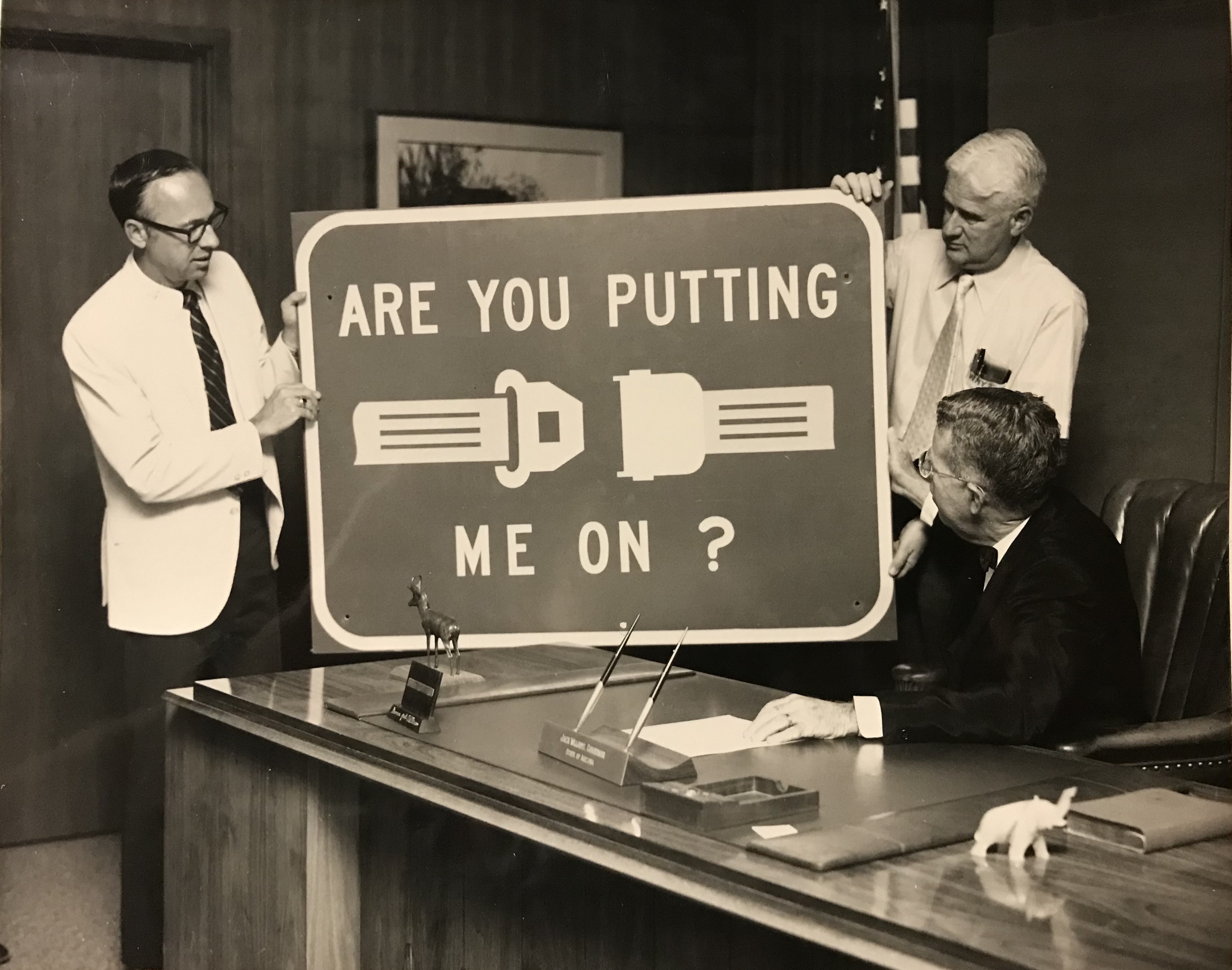 "Are you putting me on?" seat belt safety sign displayed for Governor Jack Williams