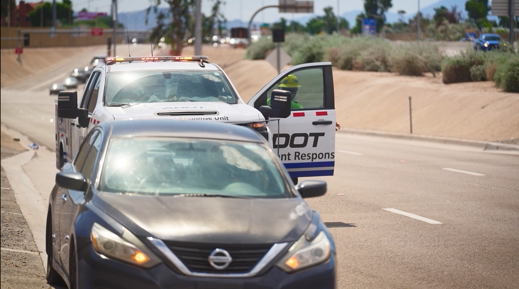 An ADOT truck assisting a stranded motorist on the side of the highway