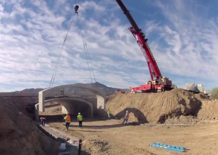 Crane installs concrete tunnel for wildlife underpass