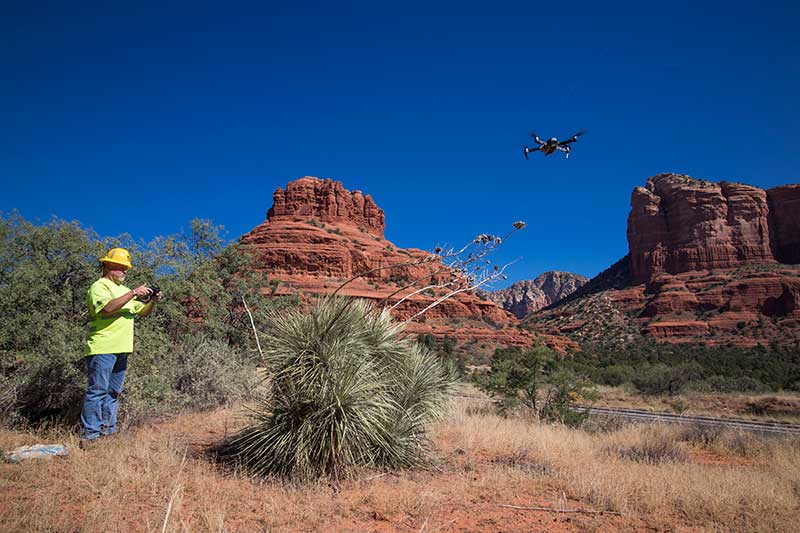 A drone pilot operates a drone in Sedona