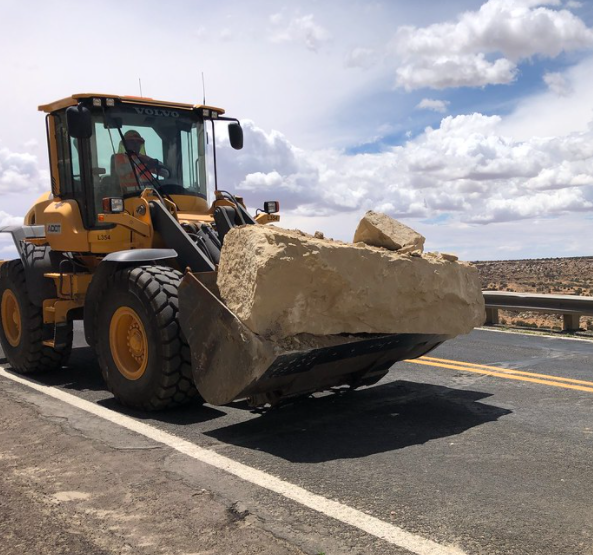 Front loader moves large rock