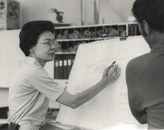 Historic photo shows female ADOT employee working with project drawing