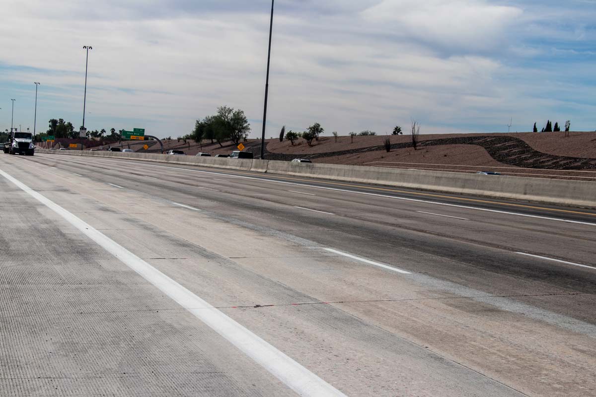 Wide view of Loop 101 freeway showing new pavement sections and desert landscaping along the corridor.