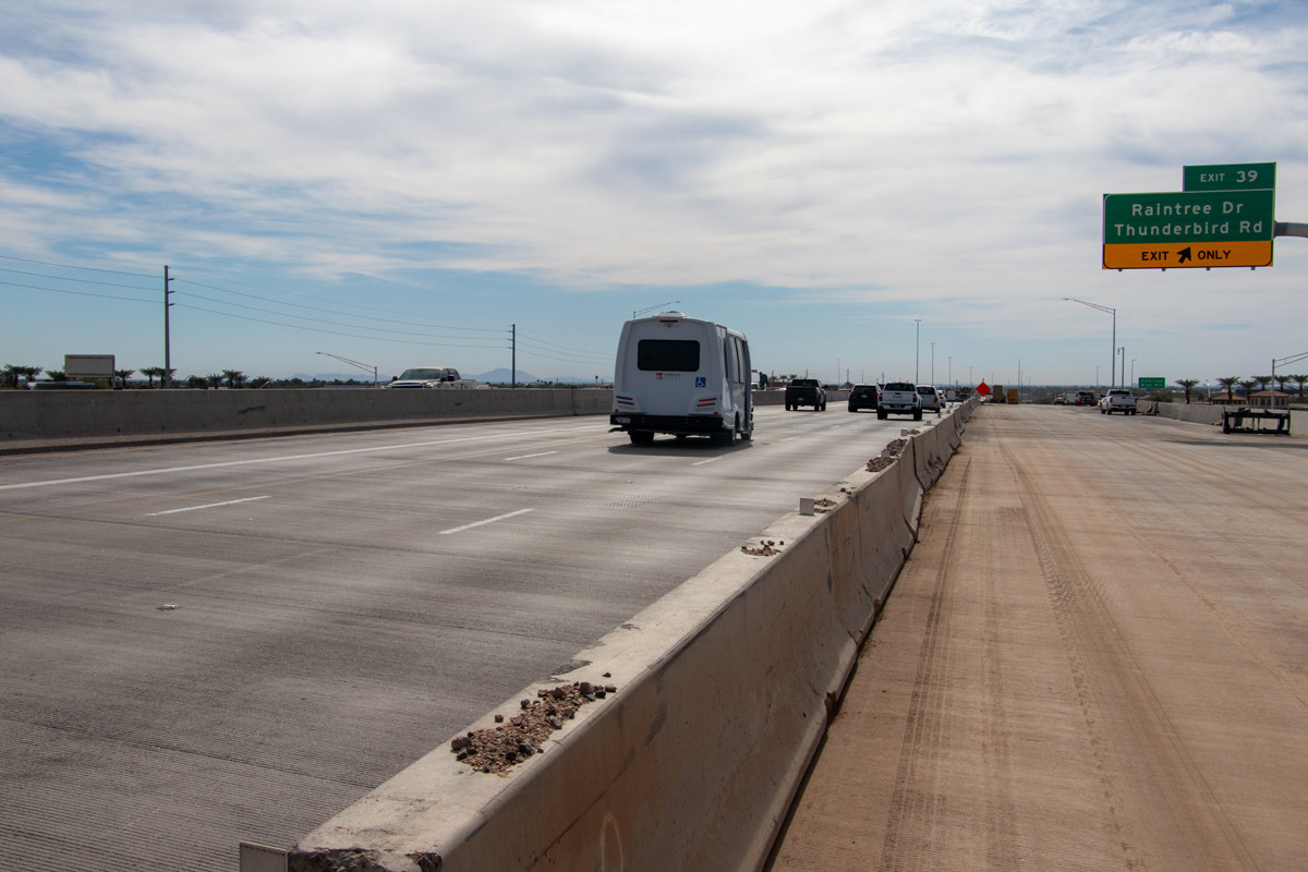 Loop 101 exit ramp for Frank Lloyd Wright Boulevard and Bell Road with a prickly pear cactus mural on the retaining wall.