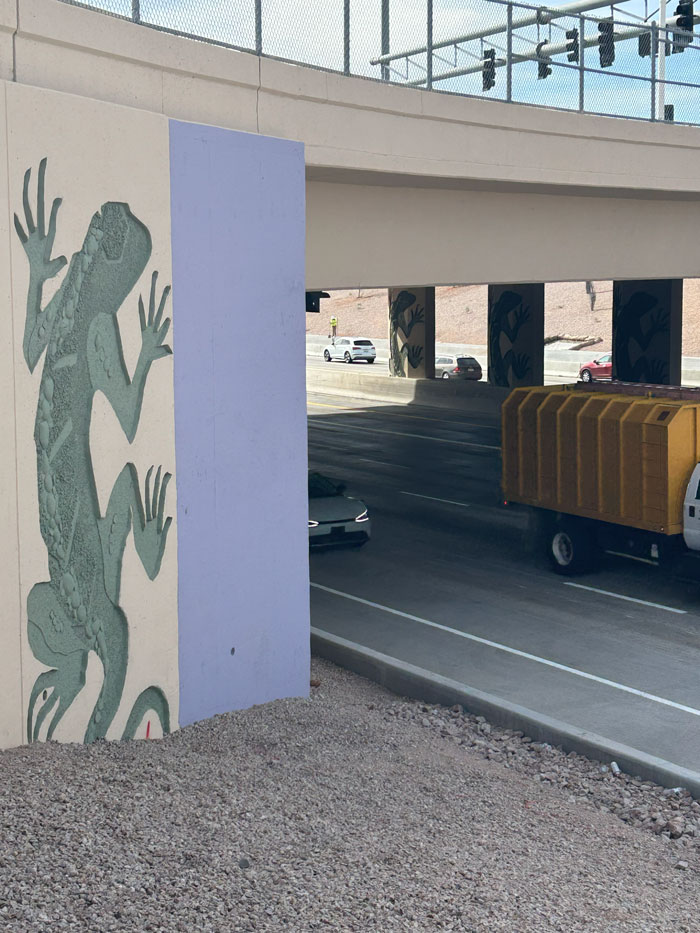 Wide-angle view of Loop 101 lanes with new pavement and construction vehicles staged near the shoulder.