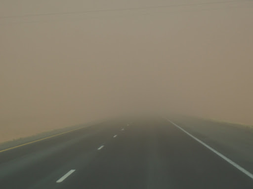 A highway is obscured by dust.