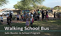 Children and adults walk together in a group outdoors for a Walking School Bus Safe Routes to School Program.