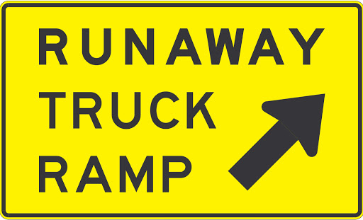 Yellow sign that reads "Runaway Truck Ramp" with an arrow pointing up