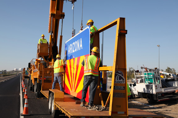 ADOT workers remove sign from trailer along highway