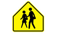 Yellow pentagon traffic sign with silhouettes of an adult and a child walking, indicating a school zone or pedestrian crossing ahead.