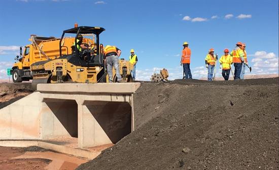 Workers and a roller complete repairs to a culvert on State Route 89.