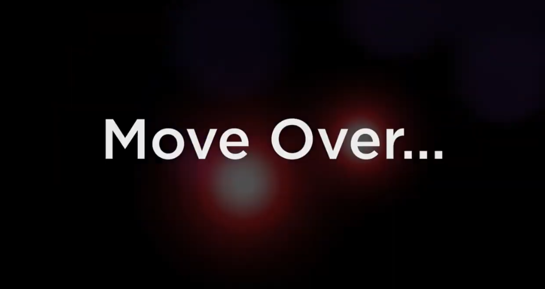 White text reading Move Over... appears centered on a dark background with faint, blurred red and white lights behind the text.