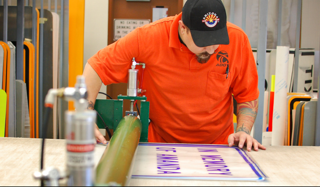 ADOT technician making a road sign.