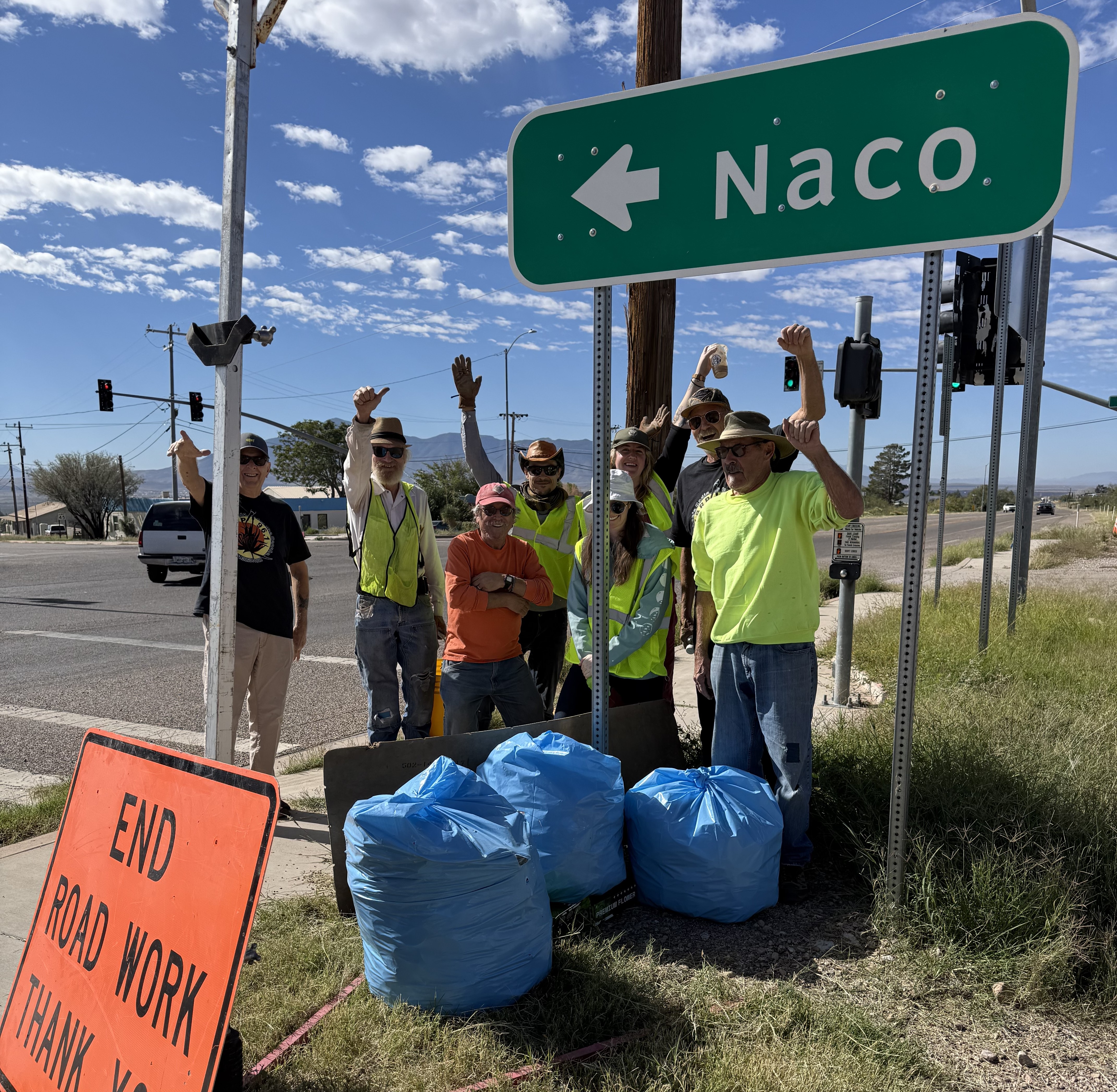 Adopt a Highway volunteers near Naco directional signage.