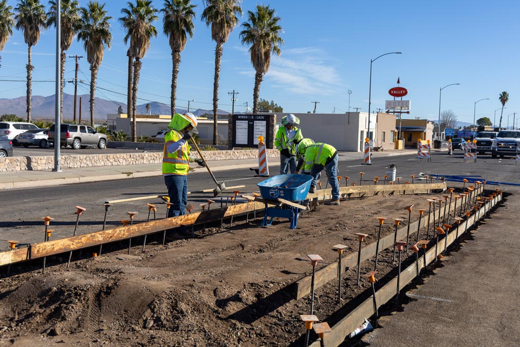 Construction crews placing concrete forms and preparing pavement improvements on US 70 as part of the Reay Lane to 8th Street pavement rehabilitation project in Arizona.